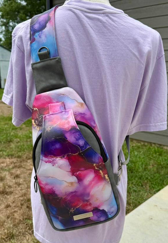 Colorful sling bag on a mannequin wearing a white t-shirt outdoors.